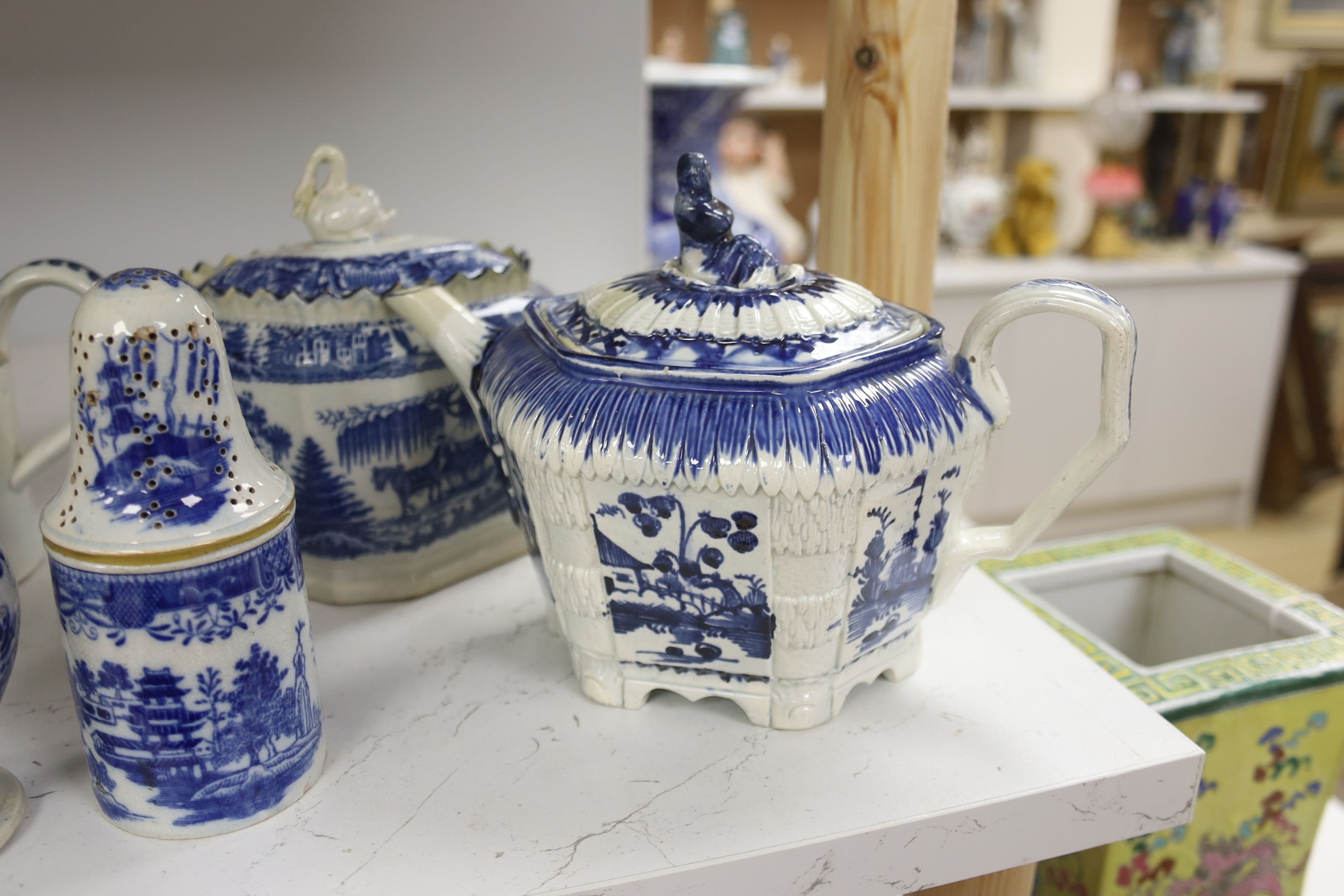 A collection of English blue and white pottery, various dates, comprising a moulded hexagonal teapot and cover, with widow finial, ovoid teapot and cover, lozenge section sugar bowl and cover, with swan finial, circular